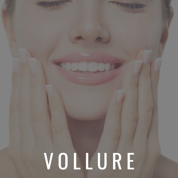 Woman touching her face and smiling from her results with Juvederm Vollure XC.