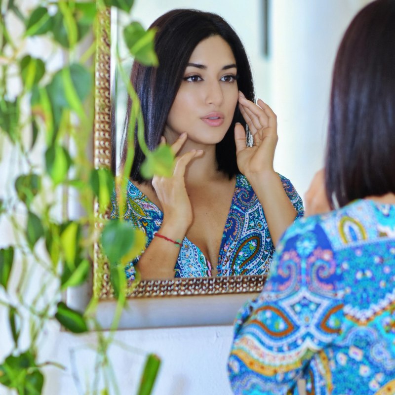 someone looking at their skin in the mirror