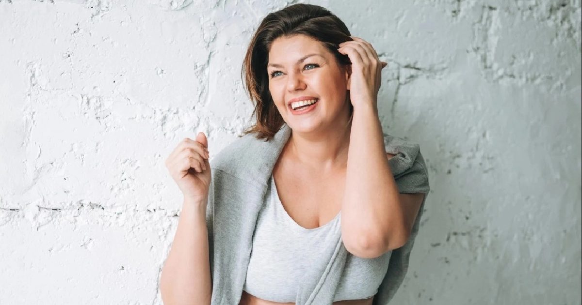 Smiling woman wearing casual activewear and looking healthy and confident.